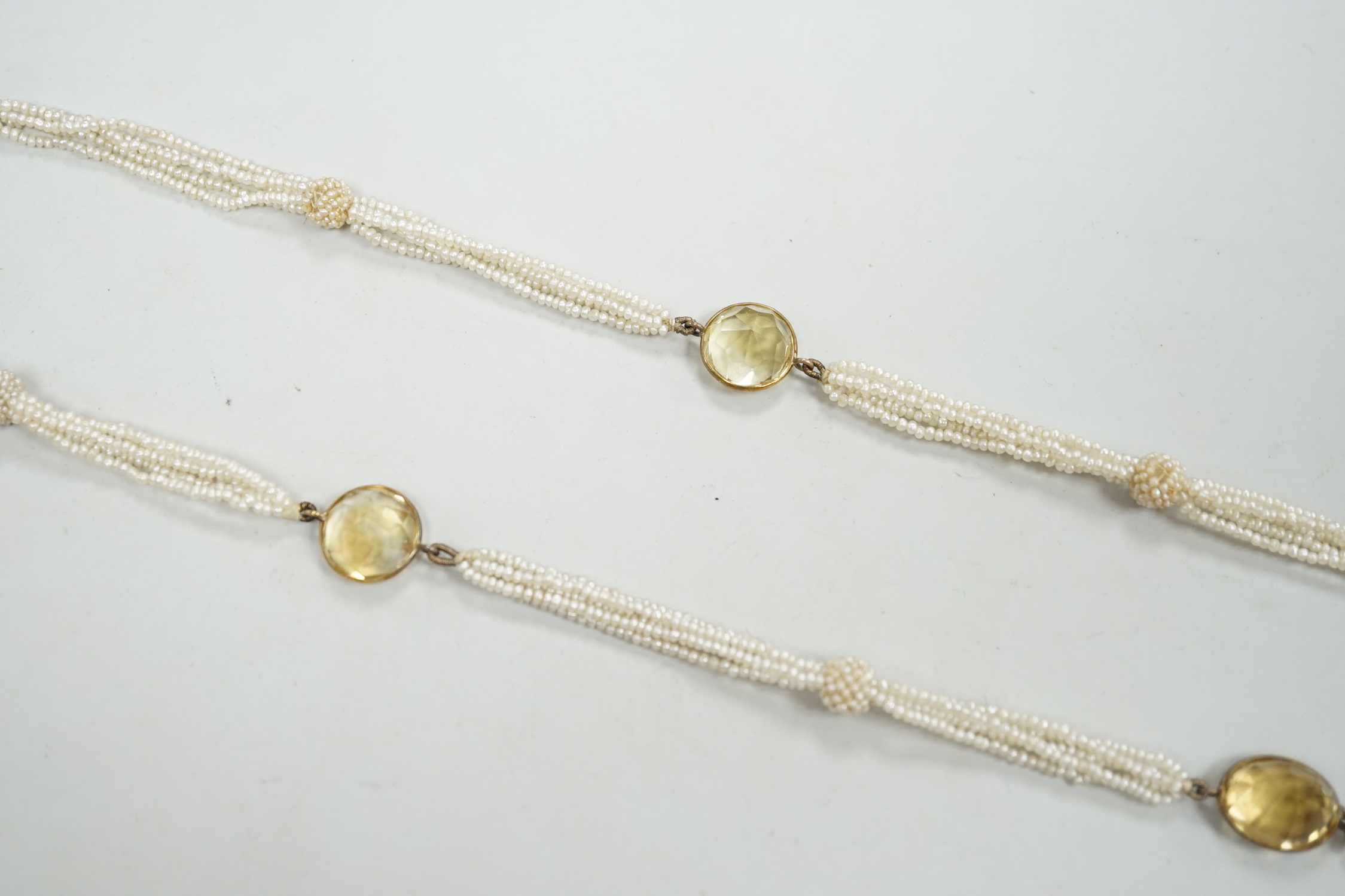 A 19th century Indian multi strand seed pearl and oval cut citrine set long necklace, with gem set tassel drops, 166cm.